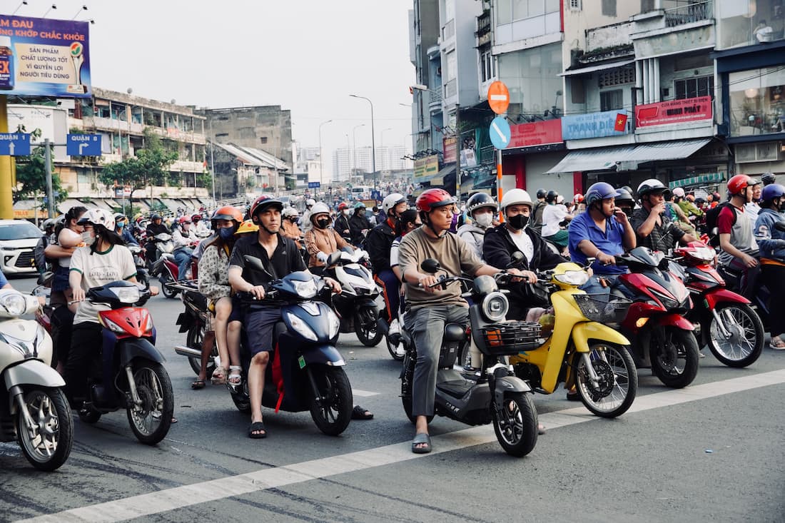 Marea de motoristas en cruce de Ho Chi Minh Saigón Vietnam el tráfico de motos más denso del sudeste asiático