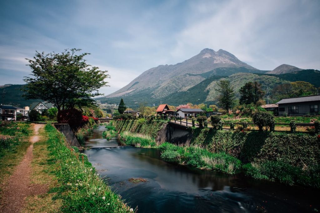 Valle rural de Yufuin con río casas tradicionales y volcán al fondo en Kyushu Japón parada del Seven Stars