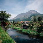 Valle rural de Yufuin con río casas tradicionales y volcán al fondo en Kyushu Japón parada del Seven Stars
