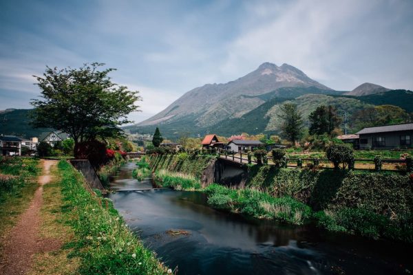 Valle rural de Yufuin con río casas tradicionales y volcán al fondo en Kyushu Japón parada del Seven Stars